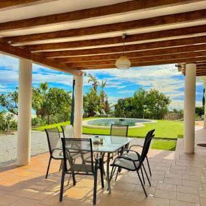eine Terrasse mit Tisch und Stühlen und einem Brunnen in der Unterkunft Casa Eclipse in Benajarafe
