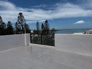 a white balcony with a view of the ocean at IsShoNi B&B in Huxi