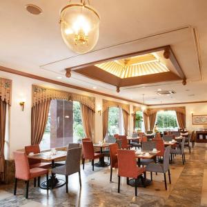 a dining room with tables and chairs and a chandelier at Hotel Sahid Jaya Solo in Solo