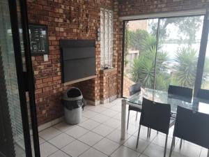 a patio with a table and chairs and a brick wall at Elephant hide away in eMalahleni