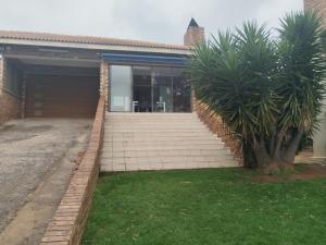 a house with a staircase in front of a building at Elephant hide away in eMalahleni