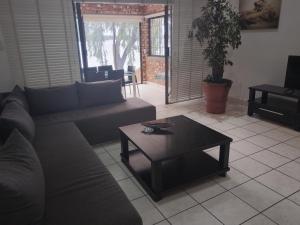a living room with a couch and a coffee table at Elephant hide away in eMalahleni