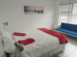 a bedroom with a bed and a blue bench at Elephant hide away in eMalahleni