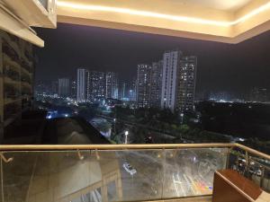 a view of a city at night from a balcony at The Mulberry Silk - Blue Saphire in Noida
