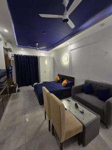 a living room with a bed and a couch at The Mulberry Silk - Blue Saphire in Noida
