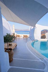 a villa with a swimming pool and the ocean at Ikastikies Suites in Firostefani