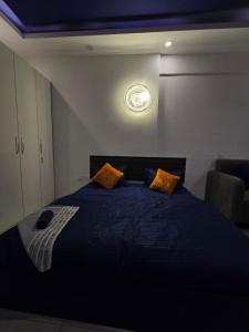 a bedroom with a blue bed with a clock on the wall at The Mulberry Silk - Blue Saphire in Noida