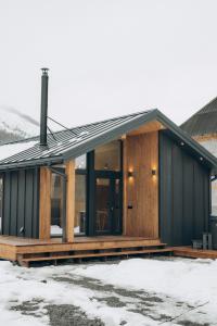 a house with a black facade with snow at Zarichna Cottage in Podgorodtsy