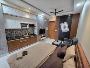 a living room with a large bed and a kitchen at The Mulberry Silk - Blue Saphire in Noida