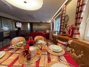 a dining room with a table with plates and vases at ALPENLOFT vom Berg zum See inklusive gratis KärntenCard in Kanzelhöhe