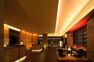 a lobby of a hotel with a desk and chairs at Yomanjo International Hotel - Prime Tianhe CBD Downtown Convenient Metro Access Short Ride to Canton Fair Diverse Room Types Free High Speed Wi-Fi 24 Hour Service in Guangzhou