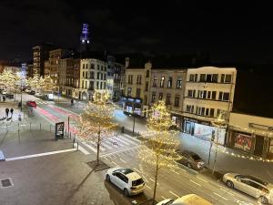 a city with cars parked on a street with christmas lights at Studio tendance Charleroi centre in Charleroi