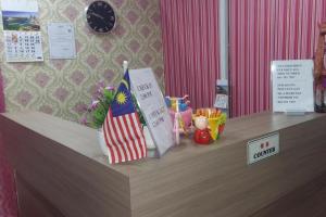 a counter with a flag and a sign on it at Confidence Motel in Kuah