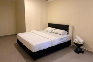 a bedroom with a large bed with white sheets at Confidence Motel in Kuah