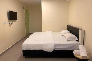 a bedroom with a large bed with white sheets and pillows at Confidence Motel in Kuah +14 photos