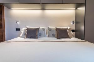 a bedroom with a large bed with pillows at HelloCHALET - Front Row with balcony overlooking the Cretaz slopes in Breuil-Cervinia