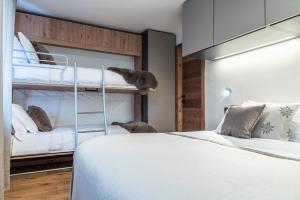 a bedroom with a bunk bed and two bunk beds at HelloCHALET - Front Row with balcony overlooking the Cretaz slopes in Breuil-Cervinia