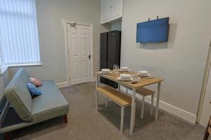 a room with a table and a chair and a tv at Elevate suites Darlington in Darlington +19 photos
