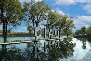 a sign that reads clao clao with trees and water at GUILIN LI RIVER CIAO Hotel in Guilin