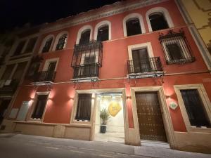 a red building with a sign in the window at De Domínguez Hotel Boutique in Seville