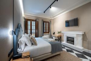 a bedroom with a bed with a fireplace and a tv at De Domínguez Hotel Boutique in Seville +42 photos