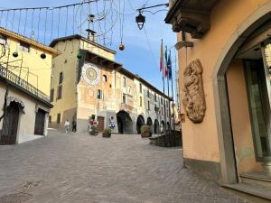 a street in a town with a building with a clock at Bilo Giudici in Clusone