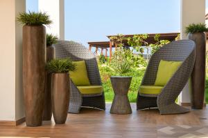a group of wicker chairs with yellow pillows on a patio at Meliá Laguna Beach - Adults Only in Santa Maria +36 photos