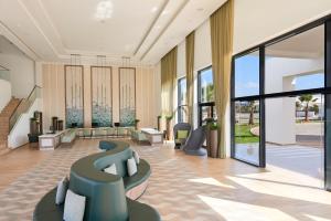 a lobby with chairs and tables and windows at Meliá Laguna Beach - Adults Only in Santa Maria