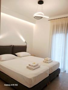a bedroom with two beds with towels on them at Lygonis White Houses in Mitika