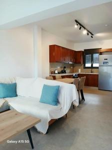 a room with a bed and a table and a kitchen at Lygonis White Houses in Mitika