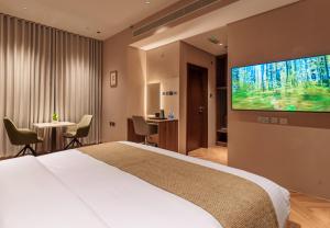 a hotel room with a bed and a flat screen tv at Jarzez Inn Hotel Azaiba فندق جرزيز إن العذيبة in Muscat