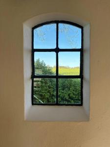 a window in a wall with a view of a field at Rural Guest House Between Simrishamn And Skillinge in Simrishamn
