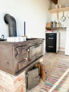 an old woodburning stove in a kitchen with a counter at Rural Guest House Between Simrishamn And Skillinge in Simrishamn