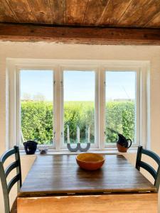 a dining room table with a view of a window at Rural Guest House Between Simrishamn And Skillinge in Simrishamn