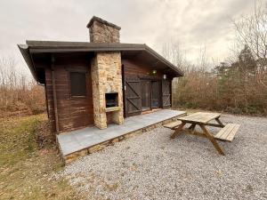 a log cabin with a picnic table and a bench at Coeur de bois - 19 in Petit Mesnil