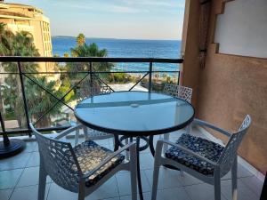 a glass table and chairs on a balcony with the ocean at Cap ô sud 2 in Cannes