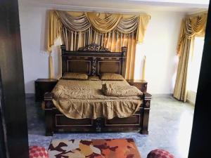 a bedroom with a large wooden bed with curtains at Bhurban Lodges in Murree