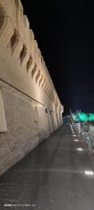 a long wall is lit up at night at Joseph's House Accommodation in Civitavecchia