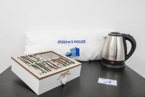 a box of utensils sitting on a table next to a kettle at Joseph's House Accommodation in Civitavecchia