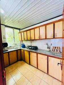 a kitchen with wooden cabinets and a large window at Bhurban Lodges in Murree