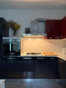 a kitchen with black cabinets and a stove top oven at Posticino apartment in Soave