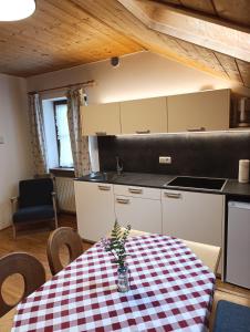 a kitchen with a table with a checkered table cloth at Brunelle, Obertörgglerhof in Brixen