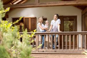 a man and a woman holding a baby on a porch of a house at Brunelle, Obertörgglerhof in Brixen