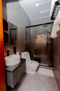 a bathroom with a toilet and a sink and a shower at One Click Cozy Suites in Kigali +63 photos