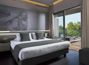 a bedroom with a large bed and a large window at NEMA Design Hotel & Spa - Small Luxury Hotels of the World in Hersonissos