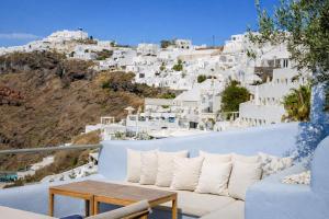 a balcony with a table and white buildings at Ikastikies Suites in Firostefani