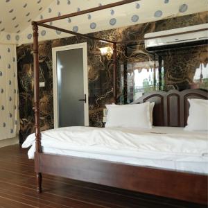 a bedroom with a canopy bed in a room at Innara Hospitality in Mori Bera
