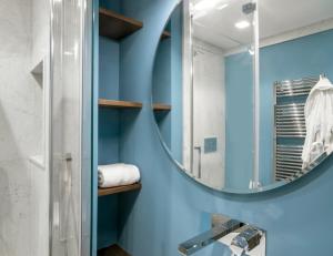 a bathroom with blue walls and a mirror at DRAGO d' ORO SUITES in Florence +76 photos