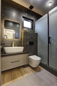 a bathroom with a sink and a toilet and a mirror at EV Hotel Baytik in Verkhnyaya Alaarcha