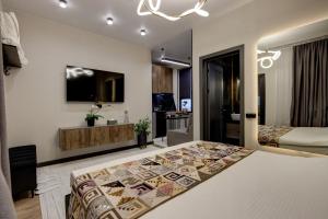 a bedroom with a bed and a tv on a wall at EV Hotel Baytik in Verkhnyaya Alaarcha +5 photos